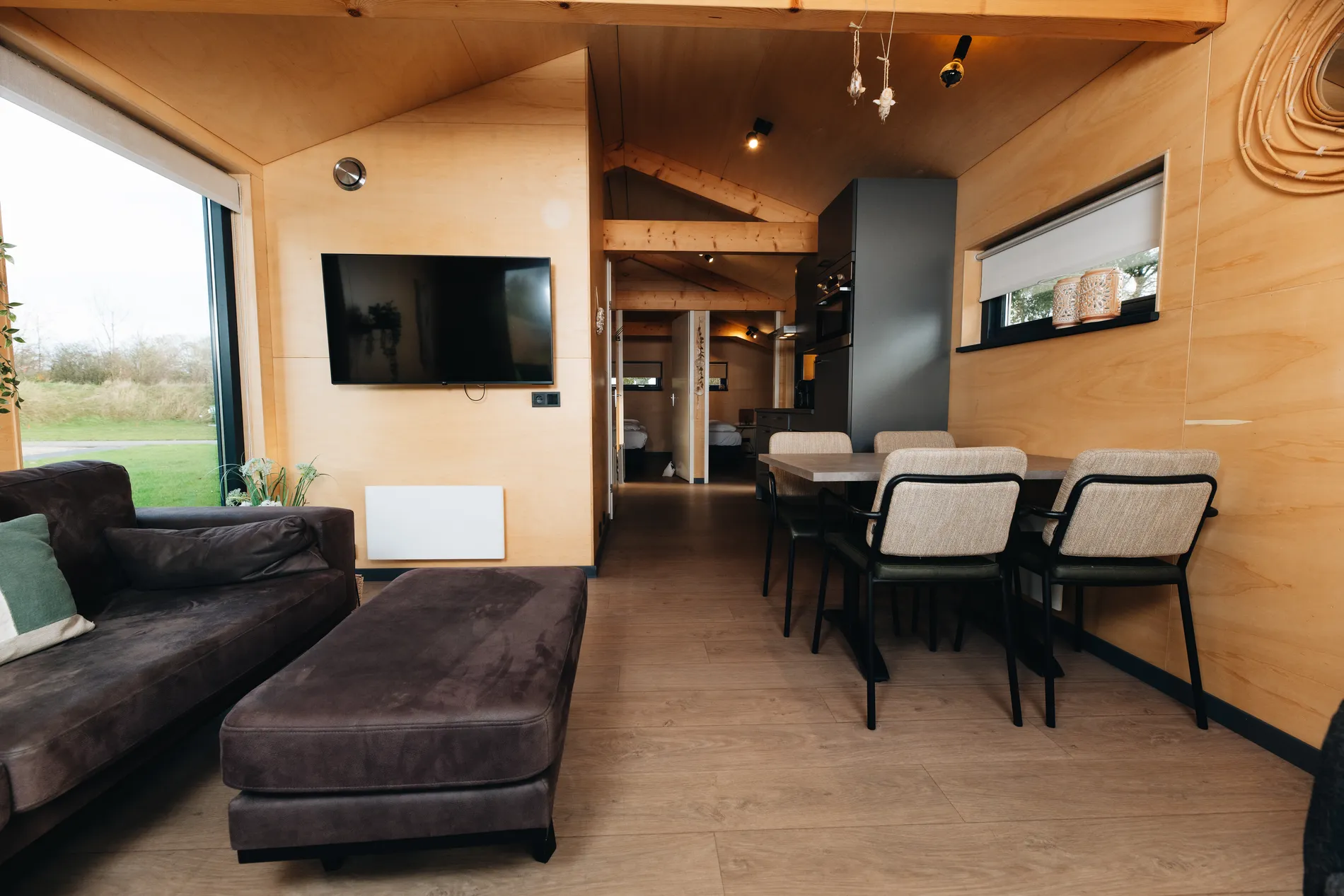 Open leefruimte en eethoek in de houten Ecolodge bij Resort Land & Zee.